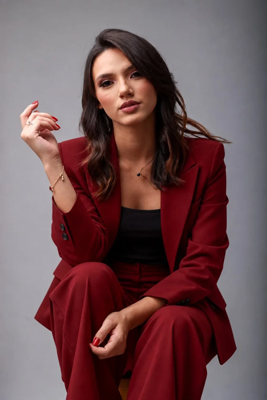 Sandy Silveira sentada, de terno vinho